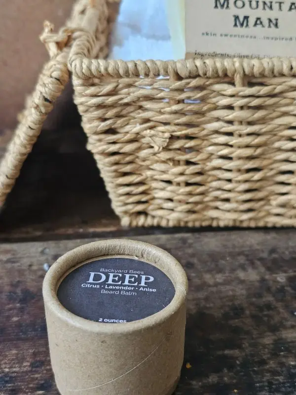 DEEP beard balm by Backyard Bees styled with other men’s grooming products in a rustic setting.