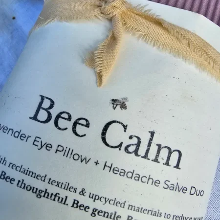 Bee-Calm-Closeup-Label Bee Calm product label and frayed cotton ribbon tied around lavender eye pillow and headache salve duo packaging.