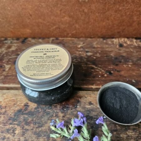 Velvet & Grit charcoal face scrub styled with lavender and raw ingredients on rustic wood background