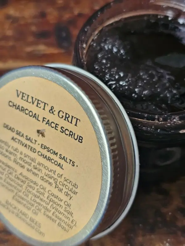 Open jar of charcoal face scrub showing rich exfoliating texture with activated charcoal and sea salts
