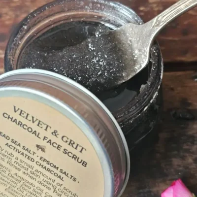 Open jar of charcoal face scrub showing rich exfoliating texture with activated charcoal and sea salts