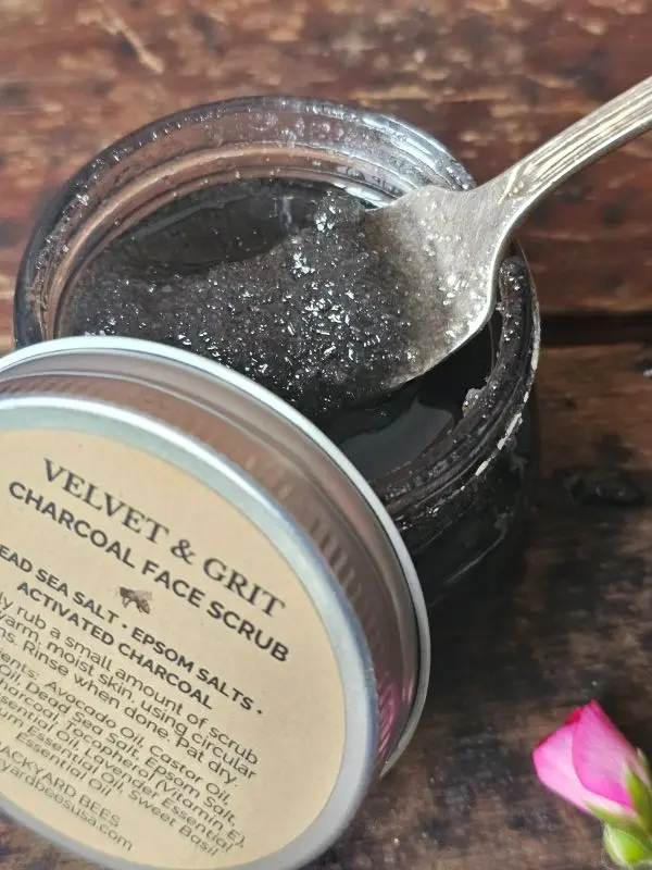Open jar of charcoal face scrub showing rich exfoliating texture with activated charcoal and sea salts