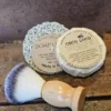 Coco-Loco-Flat-Lay Coco Loco vegan shave set on rustic wood table with kraft backdrop, featuring shave brush and vegan shave bar on soap lift.