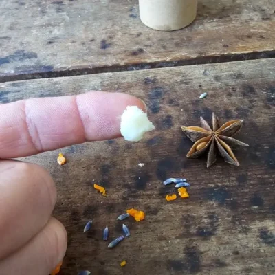 Texture of DEEP beard balm by Backyard Bees, showing a small amount of balm made with beeswax and botanical oils.