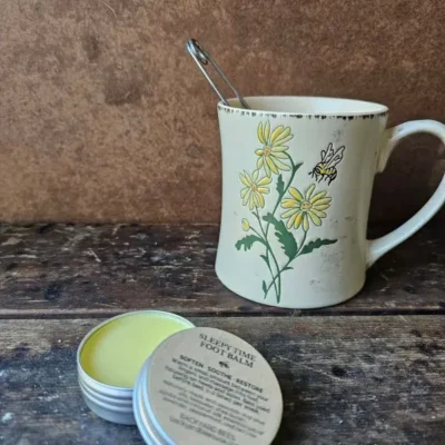 Sleepy Time Foot Balm beside chamomile tea for nighttime self-care