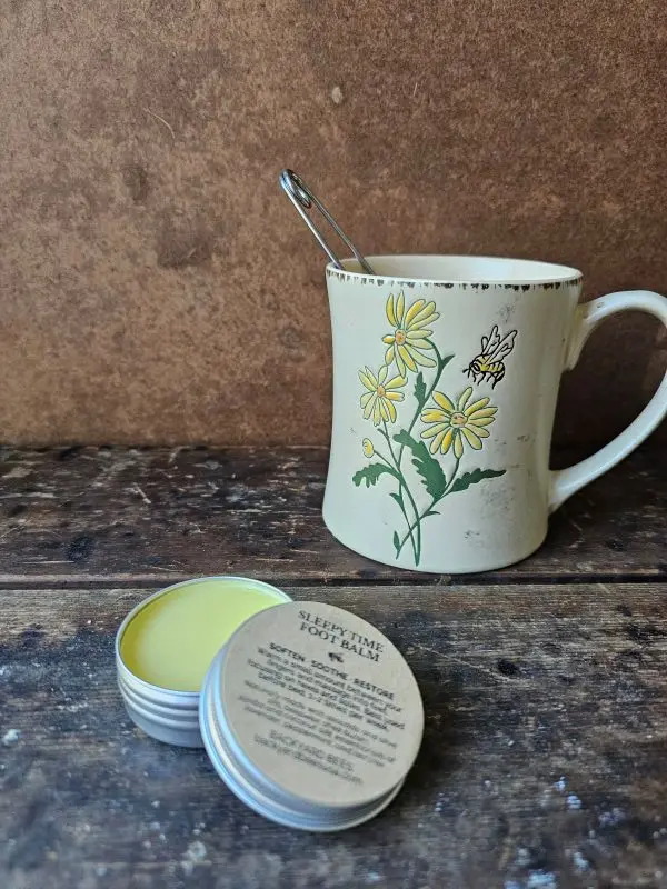 Sleepy Time Foot Balm beside chamomile tea for nighttime self-care