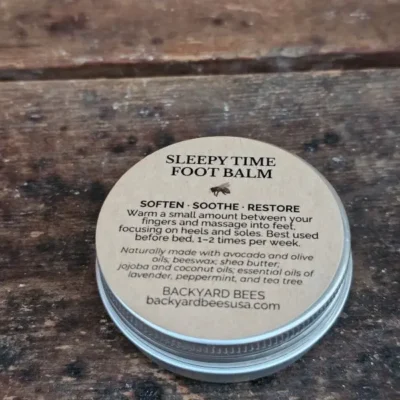 Closed tin of Sleepy Time Foot Balm on wooden surface