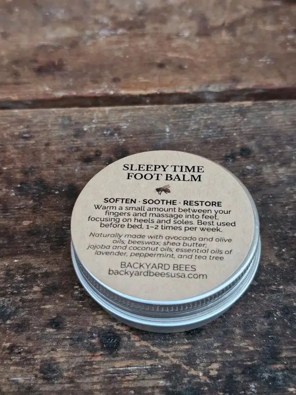 Closed tin of Sleepy Time Foot Balm on wooden surface