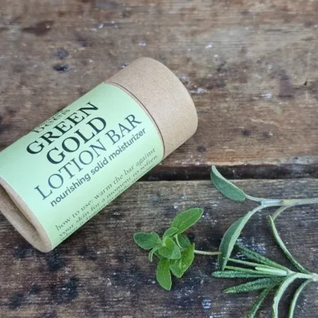 Green Gold Lotion Bar with fresh herbs highlighting botanical ingredients