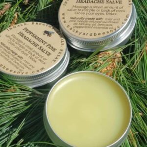 3 tins of peppermint Pine Headache Balm on a bed of fresh pine needles