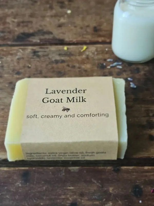 Lavender Goat Milk soap on rustic table with small jar of fresh goat milk