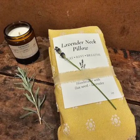 Lavender neck pillow displayed with lavender scented candle and headache salve, natural relaxation gift