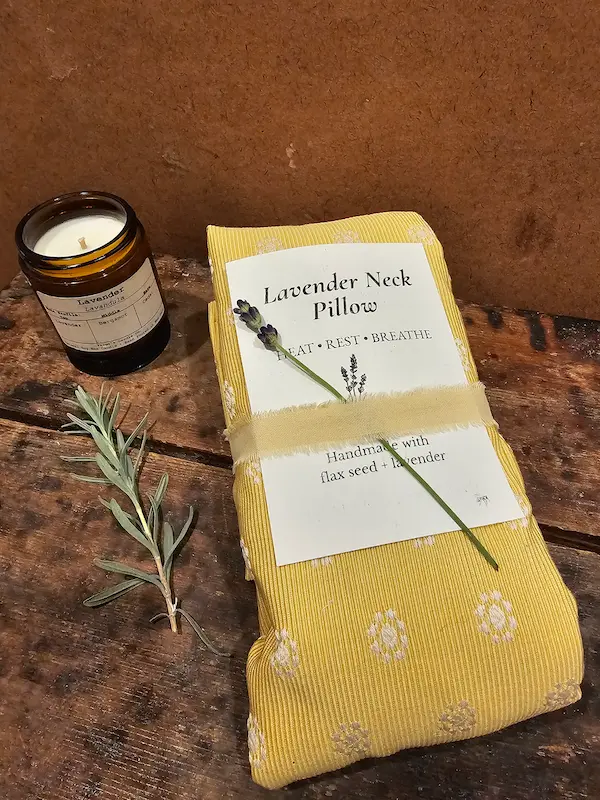 Lavender neck pillow displayed with lavender scented candle and headache salve, natural relaxation gift