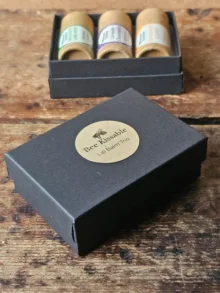 small black box with Backyard Bees Bee Kissable Lip Balm Trio printed on kraft sticker