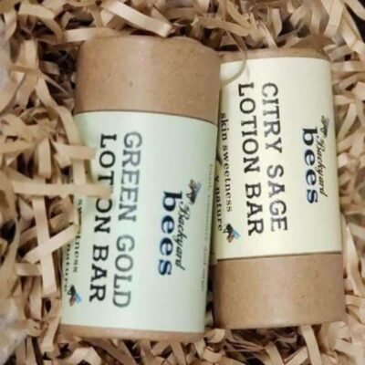 Lotion Bars two beeswax lotion bars - Green Gold and Citry Sage- on a bed of brown paper shreds