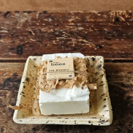 The Mariner soap bar in upcycled packaging sitting on rustic soap dish