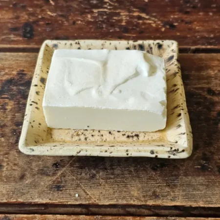 white salt water bar of soap on rustic ceramic soap dish
