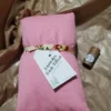 pink neck pillow on crinkled kraft brown paper, with a lavender lip balm tube