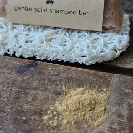 pile of rhassoul brown clay next to Rhassouli shampoo bar