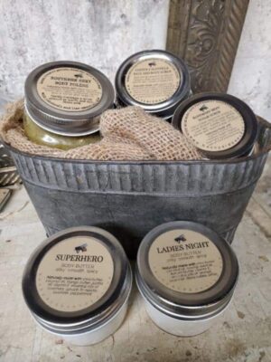 tin bucket with jars of body scrubs and body butters