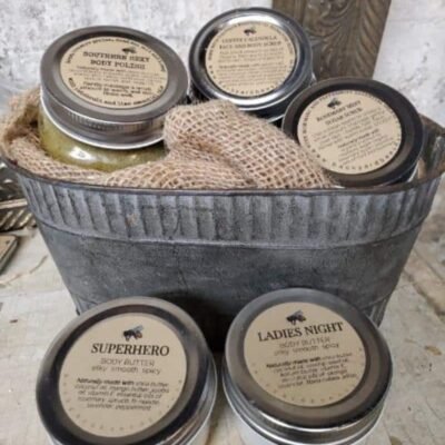 tin bucket with jars of body scrubs and body butters