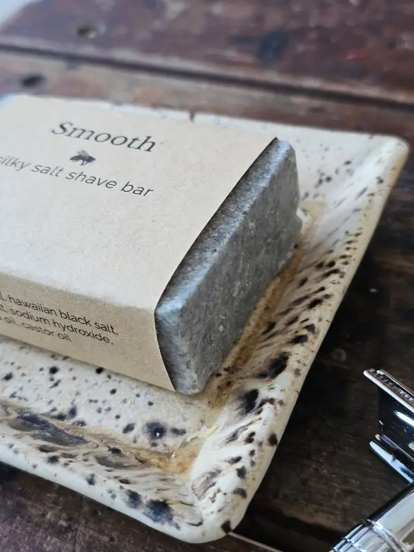 Close up of SMOOTH shave soap on rustic soap dish with stainless steel safety razor