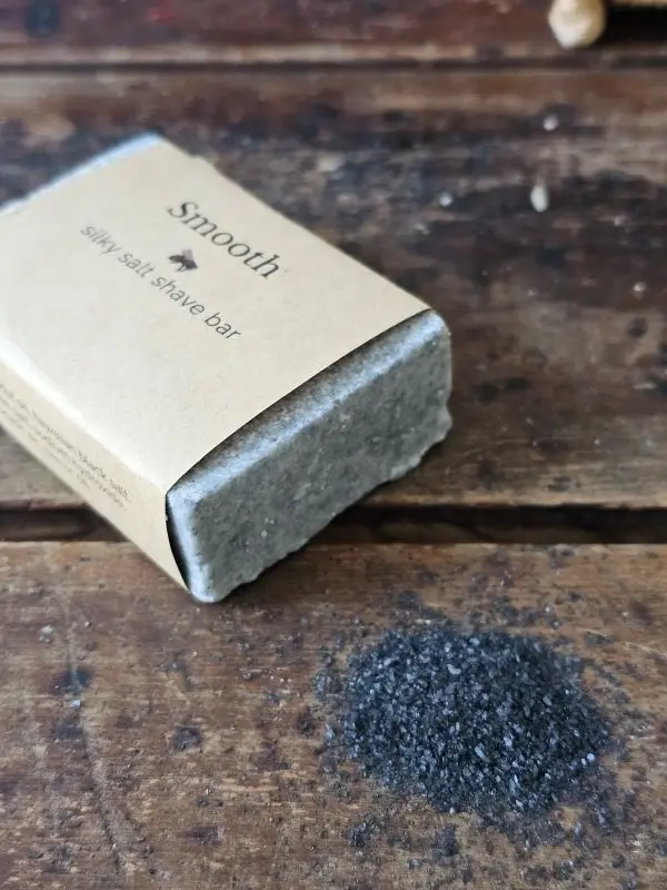 side view of SMOOTH ladies shave soap with pile of Hawaiian black sea salt
