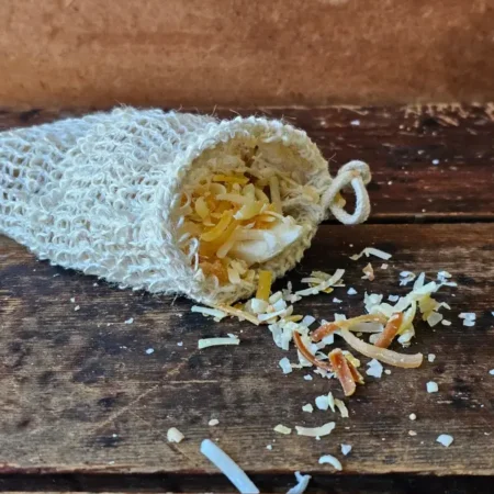 shredded soap pieces spilling out of soap saver bag on wood table