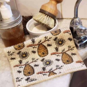 bee-themed swedish dishcloths next to sink