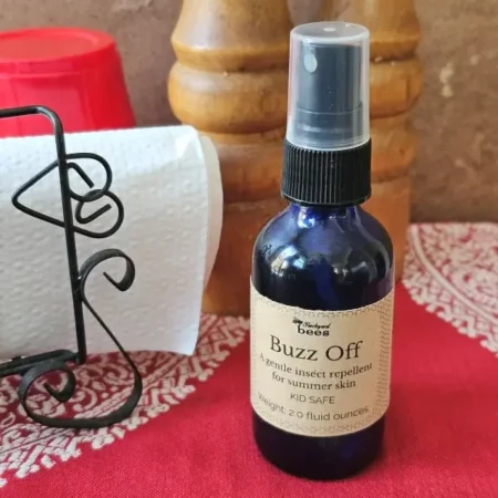 Buzz Off Barbq Buzz Off natural mosquito repellent on a backyard table, a gentle deet-free insect repellent for summer skin.