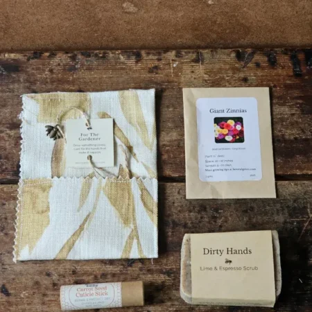 Dirty Hands soap, carrot seed cuticle stick, and zinnia seed packet beside the For the Gardener fabric envelope