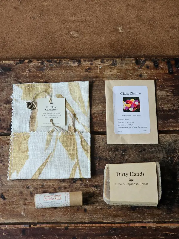 Dirty Hands soap, carrot seed cuticle stick, and zinnia seed packet beside the For the Gardener fabric envelope