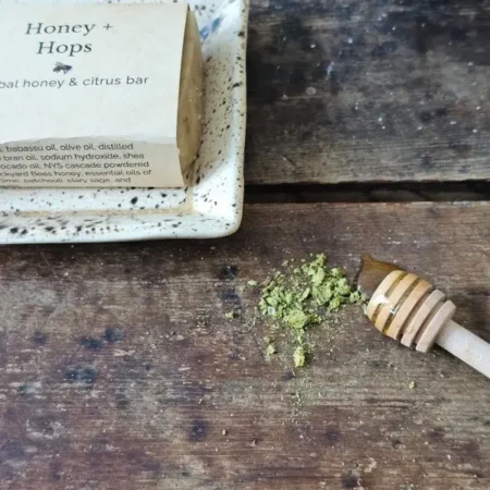a honey soap with ground hops, Honey & Hops on a soap dish with ingredients
