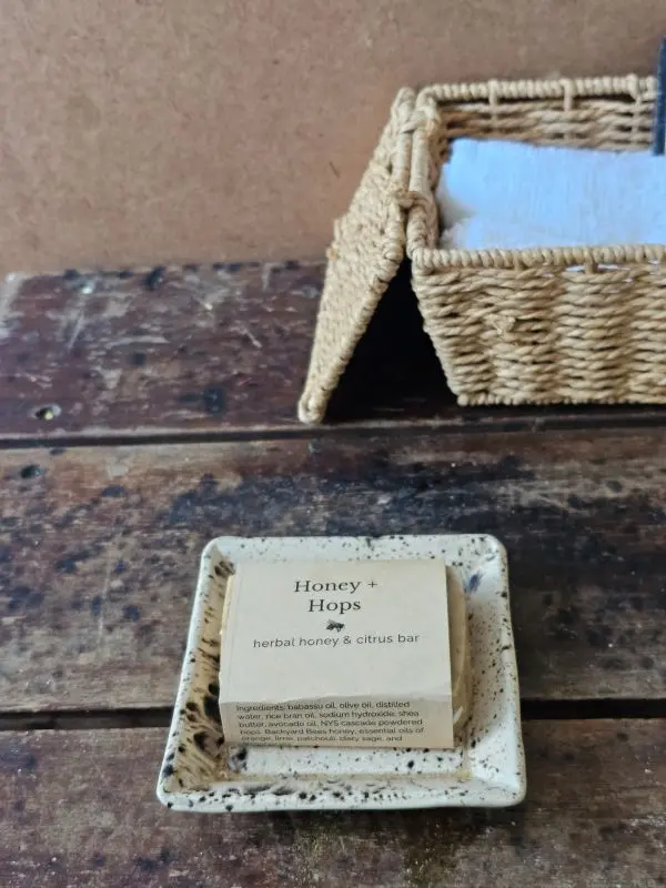 Honey & Hops styled on rustic table with soft bath cloths