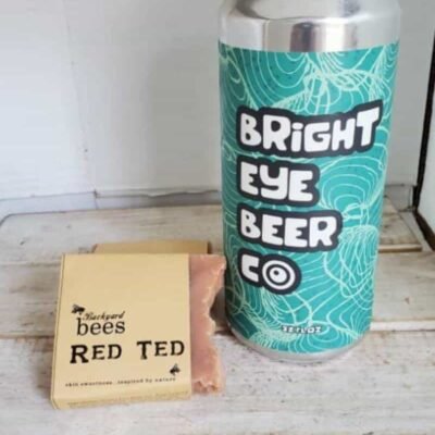 Red Ted Artisan bar of Red Ted beer soap next to tall can of Bright Eye Beer Co can