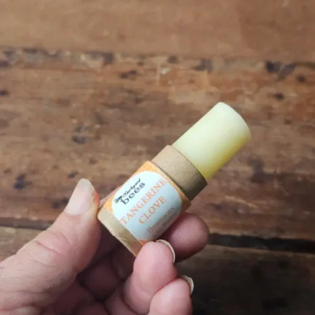 Open Tangerine Clove beeswax lip balm in a recyclable paper tube.