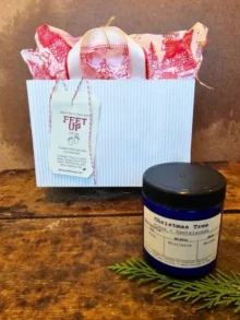 ozy spa gift set with holiday bag and seasonal soy candle on rustic wood