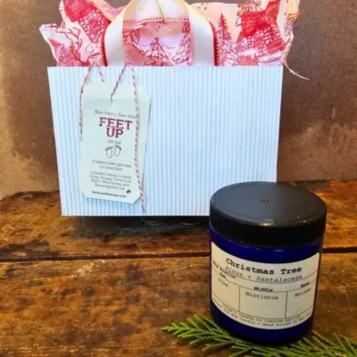 ozy spa gift set with holiday bag and seasonal soy candle on rustic wood