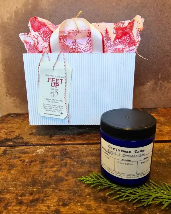 ozy spa gift set with holiday bag and seasonal soy candle on rustic wood