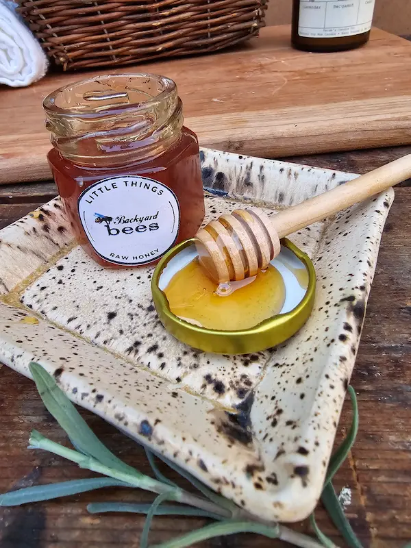 Raw honey and wooden dipper from the ritual set, ready to sweeten tea or the bath.