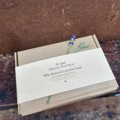 A gift-ready Milk, Honey & Lavender Bath Ritual set wrapped in a kraft belly band, styled simply for a soft, calm, natural look.