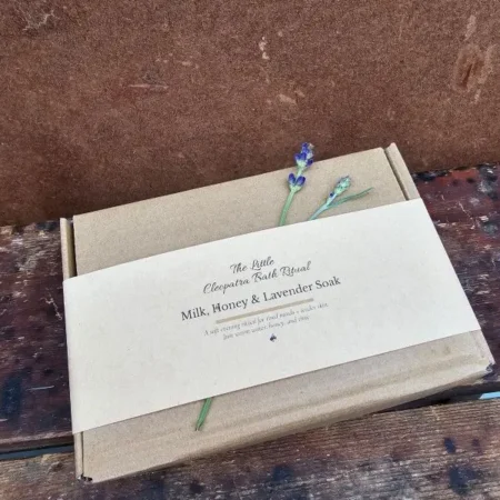 A gift-ready Milk, Honey & Lavender Bath Ritual set wrapped in a kraft belly band, styled simply for a soft, calm, natural look.