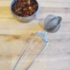 Tea-Strainer tea strainer with open tin of loose tea