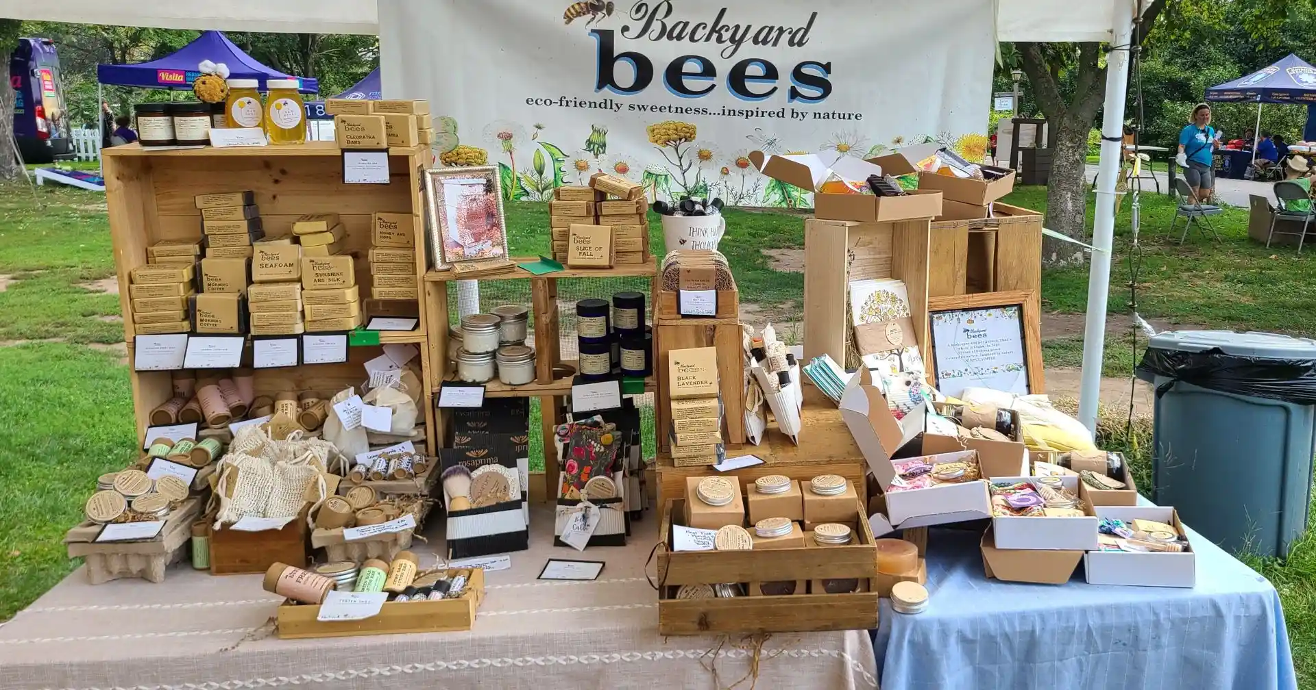 backyard-bees-hero colorful farmers market shop display of Backyard Bees natural sustainable skin care products