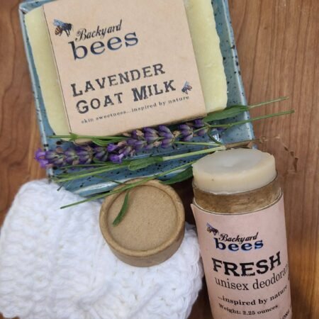 a bar of soap on a plate with lavender flowers and soft white cotton washcloth and fresh deodorant