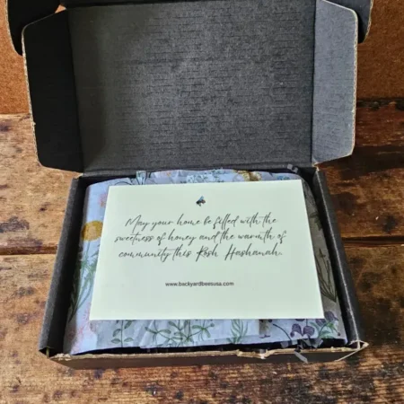 Rosh Hashanah Honey Gift Box opened to reveal a blessing card and botanical tissue