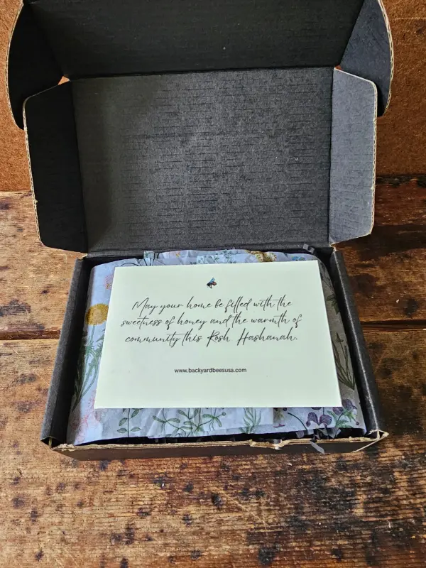 Rosh Hashanah Honey Gift Box opened to reveal a blessing card and botanical tissue