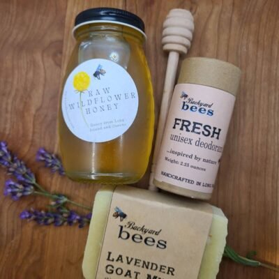 Jar of raw honey with dipper, natural deodorant, lavender soap and fresh lavender on wooden background