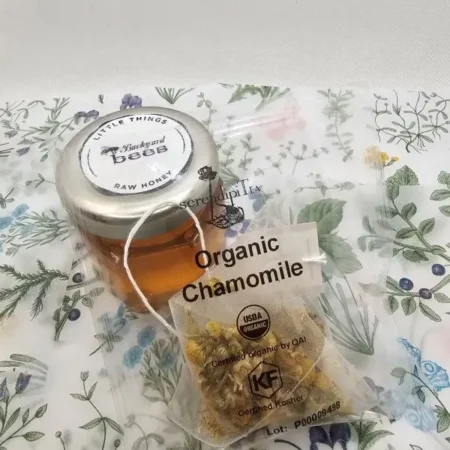 close up of raw honey and Serendiptea organic chamomile tea bag