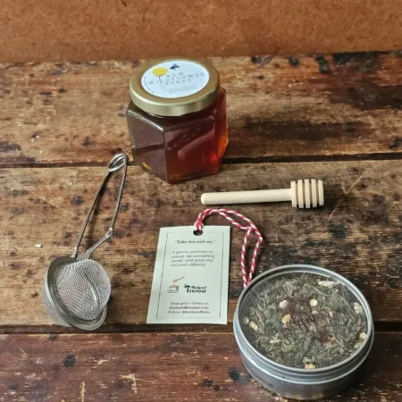 Contents Holiday Take Tea And See Holiday Take Tea & See gift contents: wildflower honey, loose-leaf tea tin, metal tea strainer, wooden honey dipper, and gift tag.